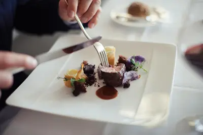 a person eating a plate of food on a table at Giardino Marling in Merano