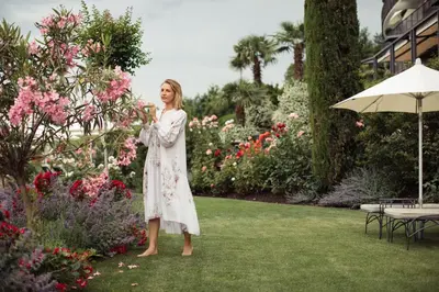 a woman in a white dress standing in a garden at Giardino Marling in Merano