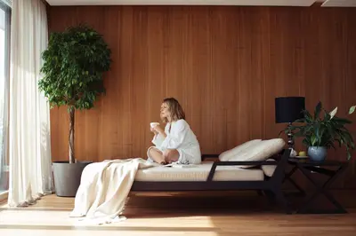 a woman sitting on a bed in a room at Giardino Marling in Merano