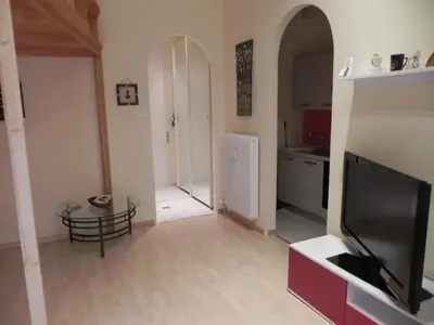a living room with a television and a kitchen at Casa Vacanze Monachy in Merano