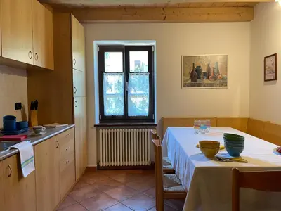 a kitchen with a table and a window at Agriturismo La Canonica in Brez
