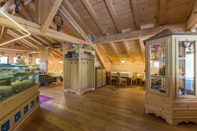 a large room with wooden ceilings and a dining room at Agritur Ciasa Dò Parè in Soraga