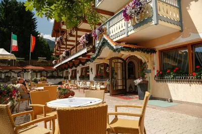 a restaurant with a table and chairs in front of a building at Hotel Malder in Soraga