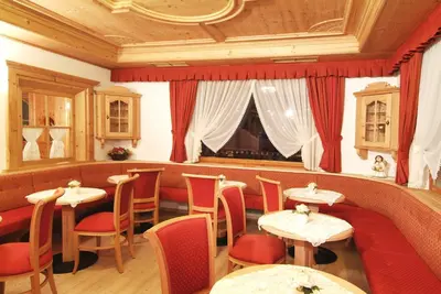 a restaurant with tables and chairs in a room at Hotel Malder in Soraga