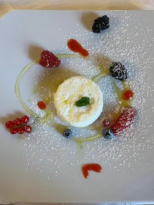 a white plate with a pastry and berries on it at Hotel Malder in Soraga