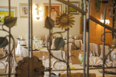 a dining room with white tables and a sunflower on the wall at Hotel Malder in Soraga