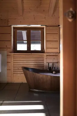 a wooden tub in a bathroom with a window at Rosapetra SPA Resort - Small Luxury Hotels of the World in Cortina dʼAmpezzo
