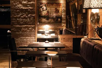 a restaurant with two tables and a brick wall at Rosapetra SPA Resort - Small Luxury Hotels of the World in Cortina dʼAmpezzo