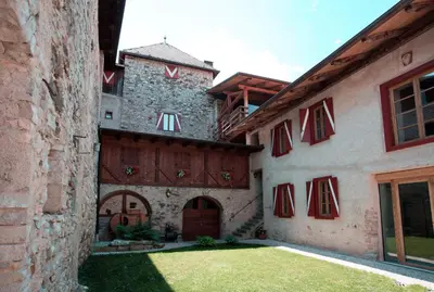 an exterior view of a building with red and white at Agritur Ciastel in Sanzeno