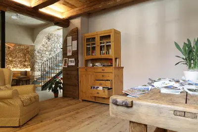 a room with a wooden cabinet and a table at Agritur Ciastel in Sanzeno