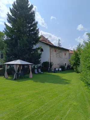 a lawn with a tent and chairs in front of a building at Agritur Ciastel in Sanzeno