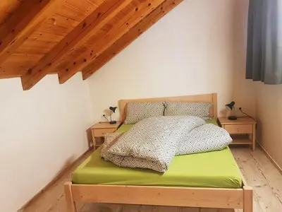a bedroom with a green bed with two night stands at Pelegrin 15 in San Vigilio Di Marebbe