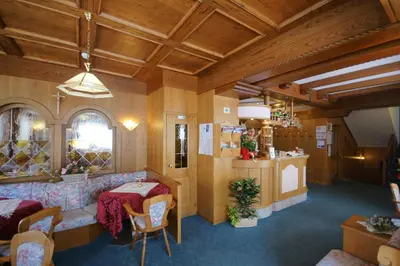 a living room with a couch and a table at Hotel Villa Cima Undici in Pozza di Fassa