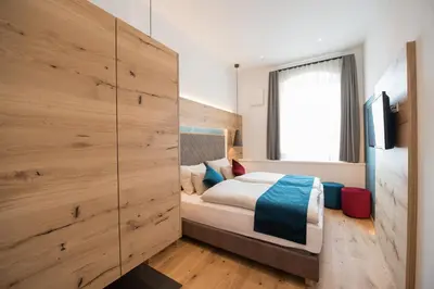 a bedroom with a bed and a large wooden wall at Apartments Windegg in Caldaro