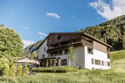a living room with a balcony with a sliding glass door at Pra Palmer The Green B&B in Ortisei