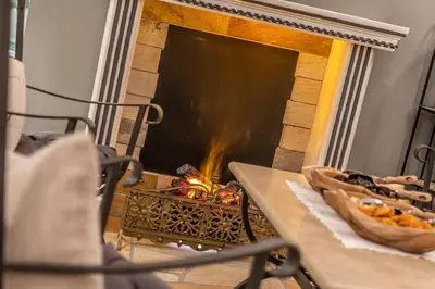 a fireplace with two pizzas sitting on a table at The Laurin Small & Charming in Selva di Val Gardena