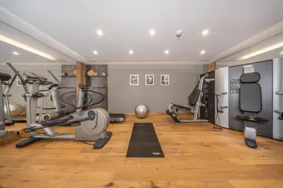a gym with treadmills and exercise equipment in a room at The Laurin Small & Charming in Selva di Val Gardena