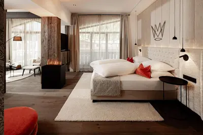 a bedroom with a bed with white pillows at The Laurin Small & Charming in Selva di Val Gardena