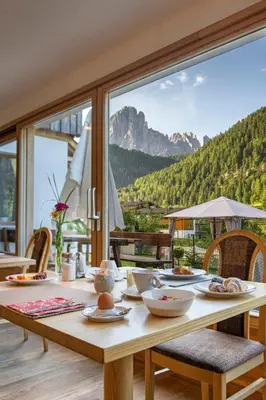 a dining table with a view of a mountain at Hotel B&B Brunello in Ortisei