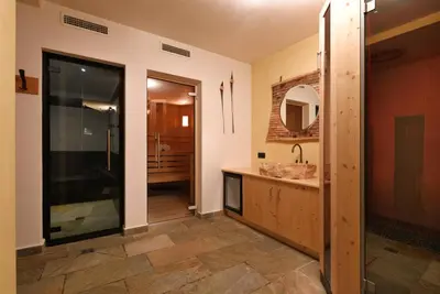 a bathroom with a shower and a sink and a mirror at Hotel B&B Brunello in Ortisei