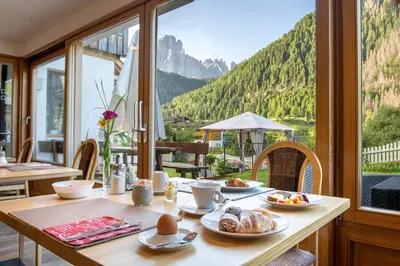 a table with food on it with a view of mountains at Hotel B&B Brunello in Ortisei