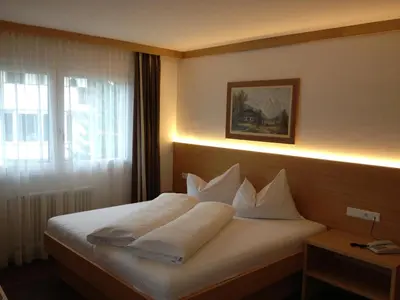 a hotel room with a bed with white pillows at Garni Flurida in Selva di Val Gardena