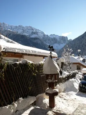 a bird feeder covered in snow next to a fence at Garni Flurida in Selva di Val Gardena