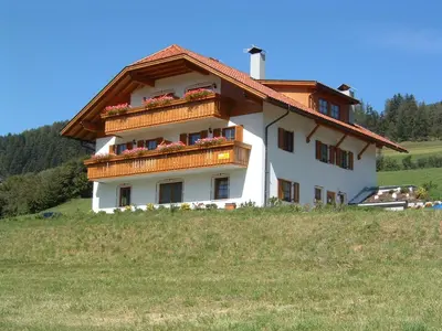 a house on a hill with flowers on it at Stegerhof in Monguelfo