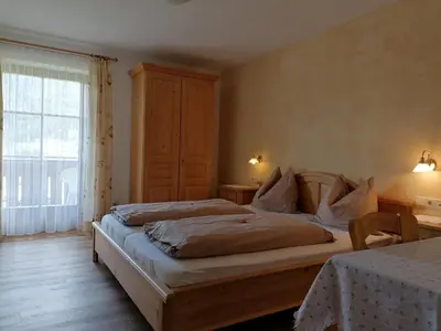a bedroom with two beds and a window at Stegerhof in Monguelfo