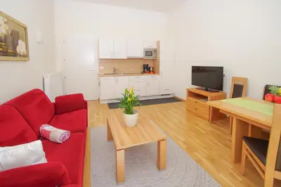 a living room with a red couch and a table at Residence Diana in Merano