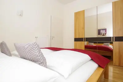 a bedroom with a white bed and a mirror at Residence Diana in Merano