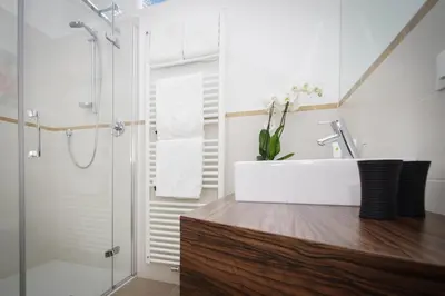 a bathroom with a white sink and a shower at Residence Diana in Merano