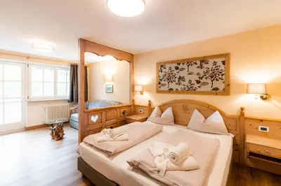 a bedroom with a large bed with towels on it at Albergo Conturina in Canazei