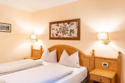 a hotel room with two beds and a picture on the wall at Albergo Conturina in Canazei