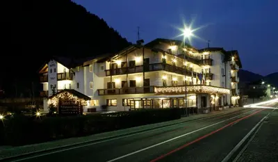 a large white building on the side of a road at Hotel Al Polo in Ziano di Fiemme