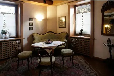 a room with a table and chairs and two windows at Hotel Al Polo in Ziano di Fiemme