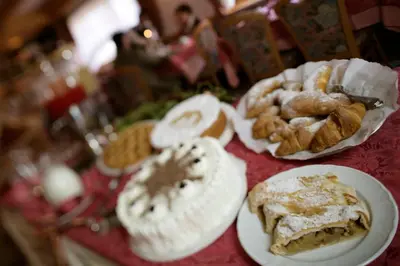 a table topped with plates of pastries and other foods at Hotel Al Polo in Ziano di Fiemme