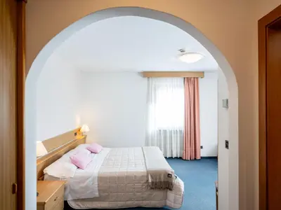 a bedroom with a bed with pink pillows at Hotel Al Polo in Ziano di Fiemme