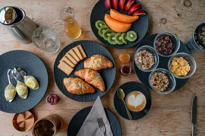 a wooden table topped with plates of food and snacks at Gailerhof Boutique Hotel B&B Dolomites in Monguelfo