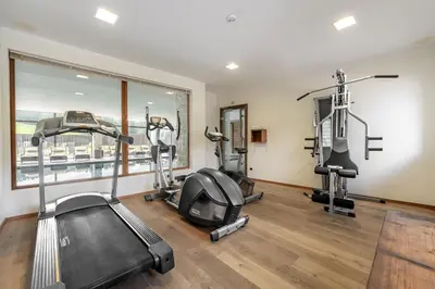 a gym with two treadmills and two ellipticals at Monte Pana Dolomites Hotel in Santa Cristina in Val Gardena