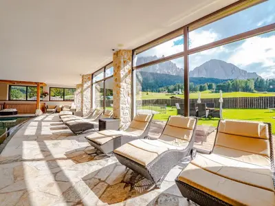 a living room with chairs and a large window at Monte Pana Dolomites Hotel in Santa Cristina in Val Gardena