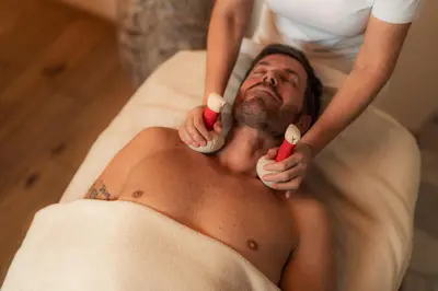 a shirtless man getting his hair brushed by a therapist at Monte Pana Dolomites Hotel in Santa Cristina in Val Gardena