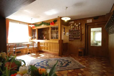 a room with a bar with a table and a window at Hotel Ancora in Moena