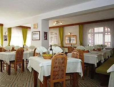 a restaurant with tables and chairs with white table cloth at Hotel Ancora in Moena