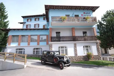 an old car parked in front of a building at Hotel Ancora in Moena
