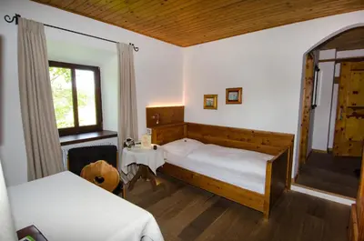 a bedroom with a large bed and a window at Hotel Ansitz Kematen ***S in Collalbo