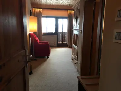 a hallway with a red chair and a window at Hotel Ansitz Kematen ***S in Collalbo