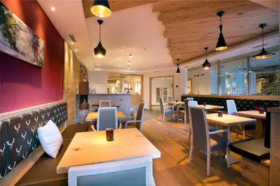 a restaurant with tables and chairs and a bar at Chalet Marcora in Campitello di Fassa