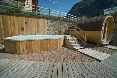 a jacuzzi tub sitting next to a building at Chalet Marcora in Campitello di Fassa