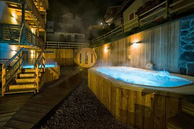 a large wooden bath tub in a room with stairs at Chalet Marcora in Campitello di Fassa
